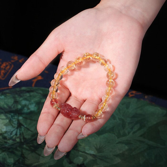 Golden rutilated quartz and strawberry quartz pixiu elastic rope bracelet.
