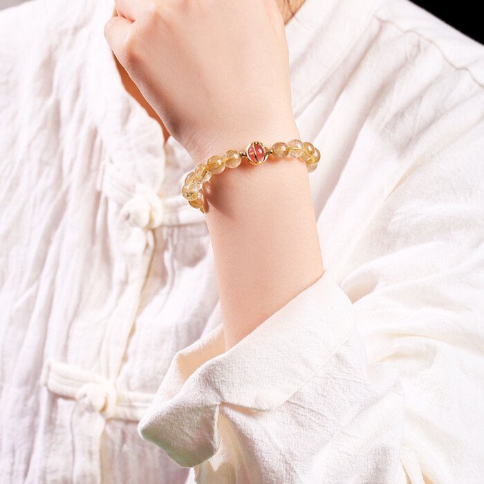 Golden rutilated quartz and strawberry quartz pixiu elastic rope bracelet.